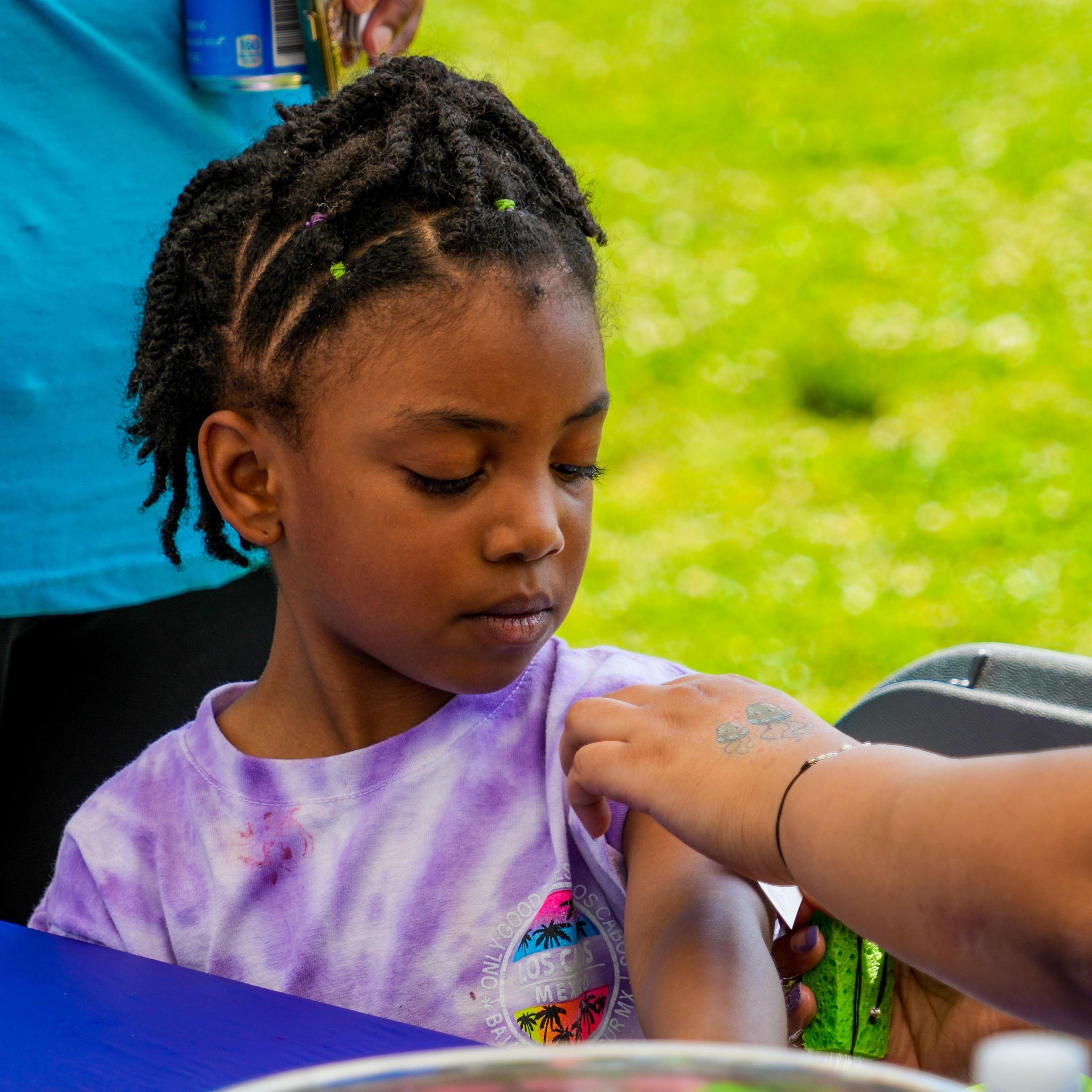 A kid getting a temporary tatoo