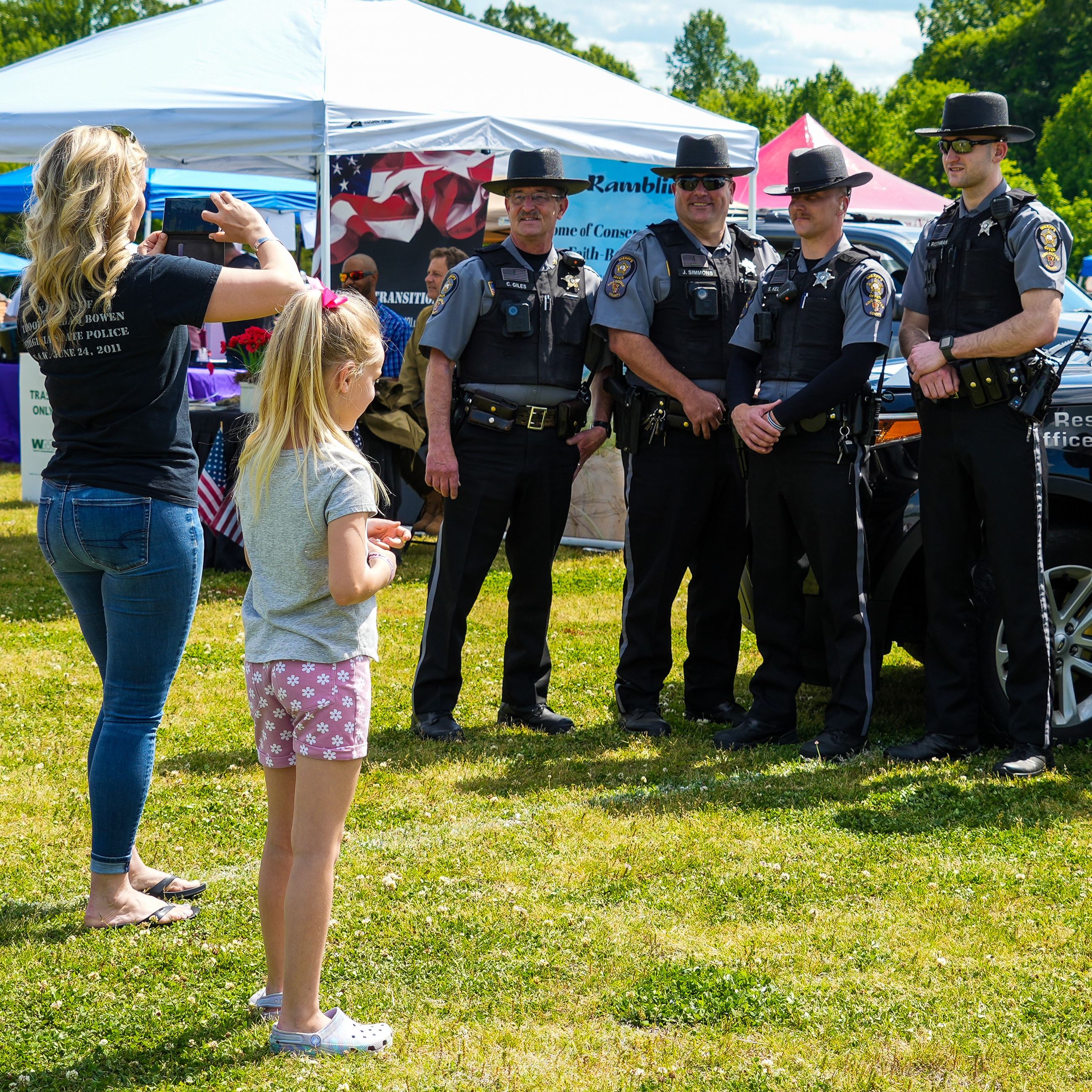 Family taking a photo of deputies in front of a DARE SUV