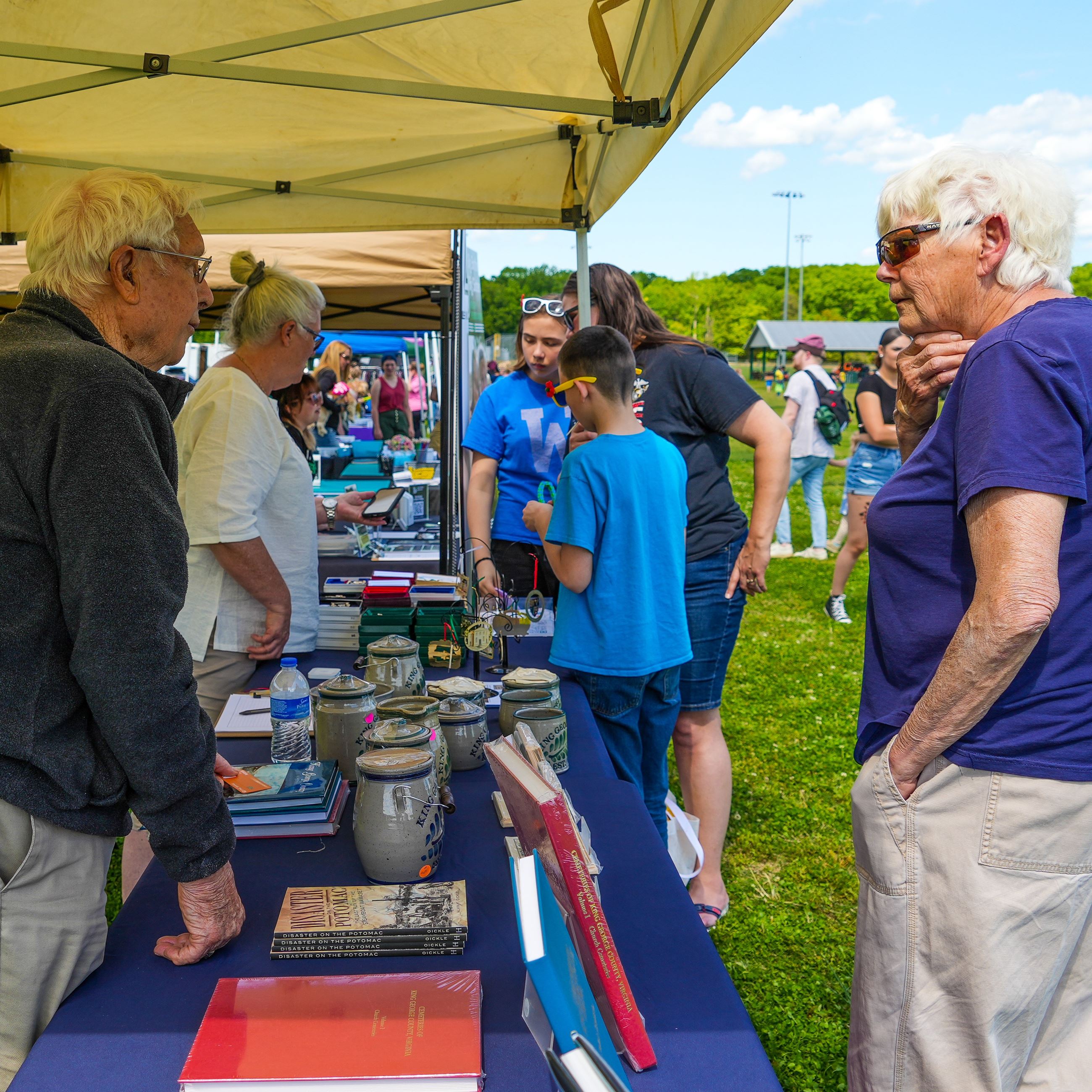 A group of people discussing their vendor booth with a patron