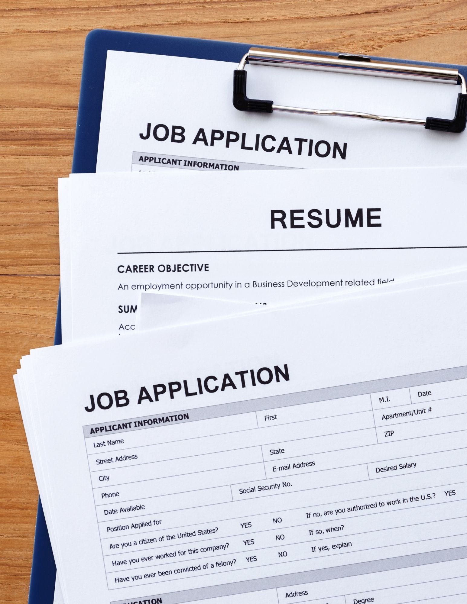 A series of papers with the words resume and job applications on them on a wooden table